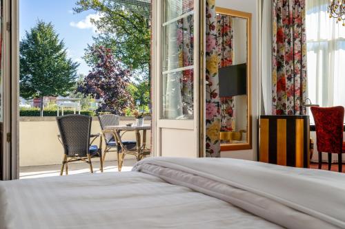 a bedroom with a bed and a view of a patio at Hotel Villa am Stadthafen in Neustrelitz