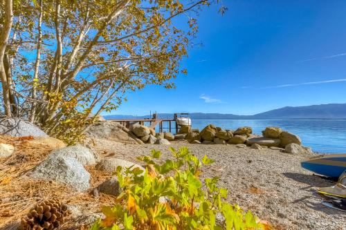 a sandy beach with a tree and the water at Cascade Charms in South Lake Tahoe
