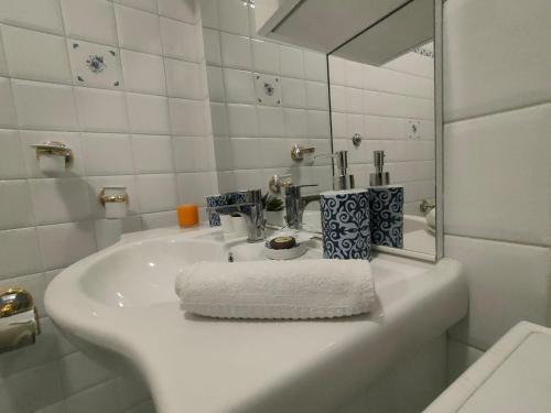 a white bathroom with a sink and a mirror at Il cielo di Raffaello in Urbino