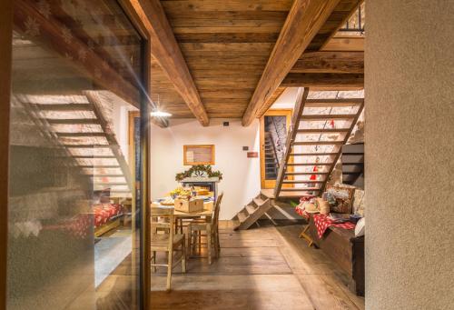 a room with wooden ceilings and a dining room with a table at Baita Relais La Cesarina in Vico Canavese