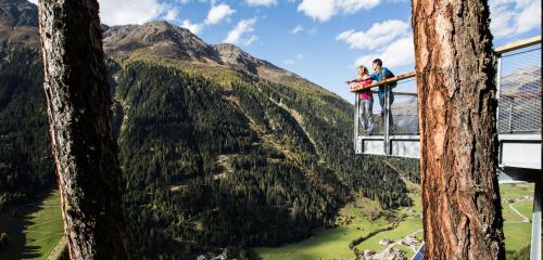 a man and a woman standing on top of a tree at s Lois Schönes Apartment im Kaunertal in Kaunertal