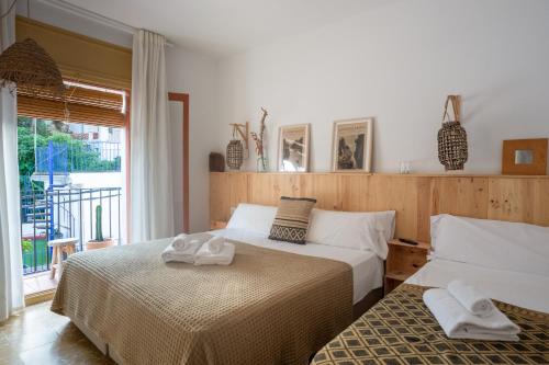 a bedroom with two beds with towels on them at Hostal Sa Teula in Llafranc