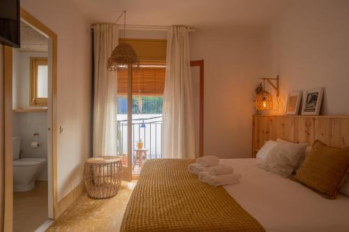 a bedroom with a bed with towels on it at Hostal Sa Teula in Llafranc