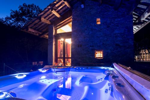 a bath tub in front of a building at night at Baita Relais La Cesarina in Vico Canavese