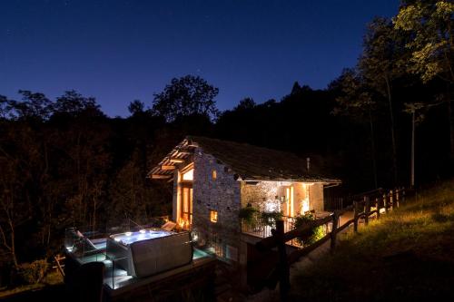 a small stone house with lights on it at night at Baita Relais La Cesarina in Vico Canavese