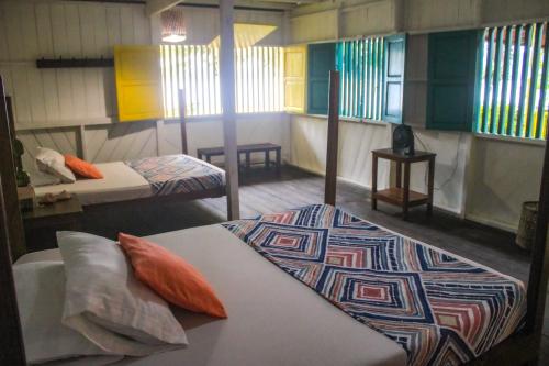 a room with two beds and a rug on the floor at Refugio Mr Jerry Eco House in Bahía Solano