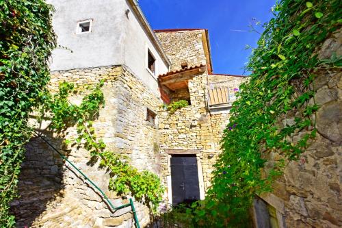 an old stone building with a door and a window at Villa Luna in Motovun
