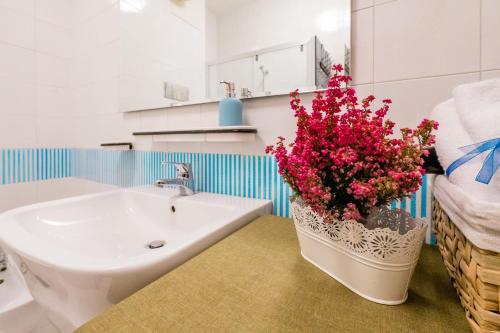 La salle de bains est pourvue d'un lavabo et d'un vase fleuri. dans l'établissement FEEL - Salvecchio Apartments, à Bergame