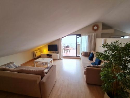 a living room with two couches and a tv at Exclusive Beachfront Penthouse in Almayate Alto