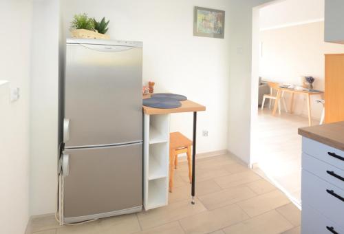 einen Kühlschrank in einer Küche mit einem Tisch in der Unterkunft Między Parkami in Sandomierz