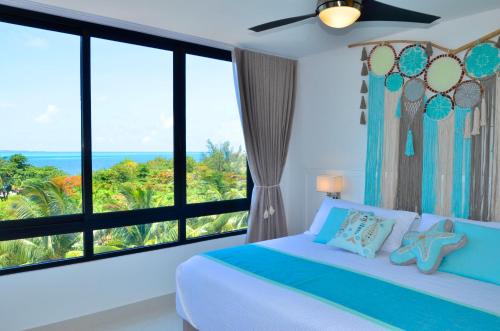 a bedroom with a bed with a view of the ocean at TAKH Sea View Apartment in Cancún