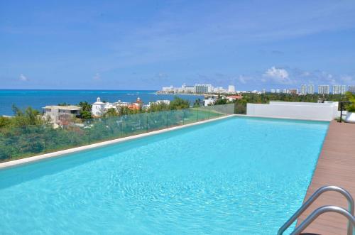a swimming pool with a view of the ocean at TAKH Sea View Apartment in Cancún