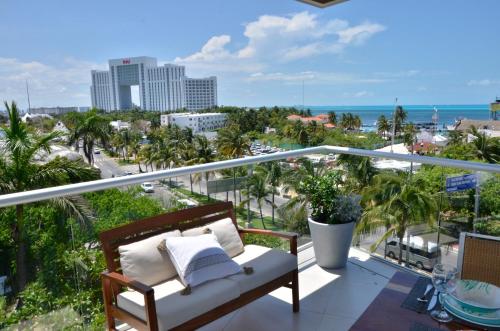a balcony with a bench and a view of the ocean at TAKH Sea View Apartment in Cancún