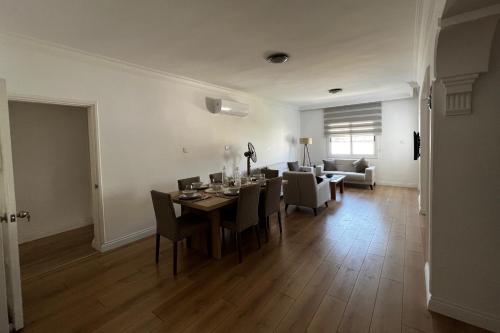 凱里尼亞的住宿－Stylish 3 BR apartment in Kyrenia Northern Cyprus，用餐室以及带桌椅的起居室。