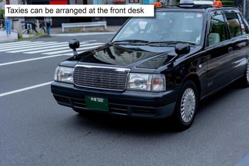 a black car is parked on a city street at hotel MONday Premium TOYOSU in Tokyo