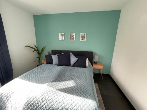 a bedroom with a bed with a blue wall at Airport Apartment für 4 - Smart TV - Küche - eCharger in Hamburg