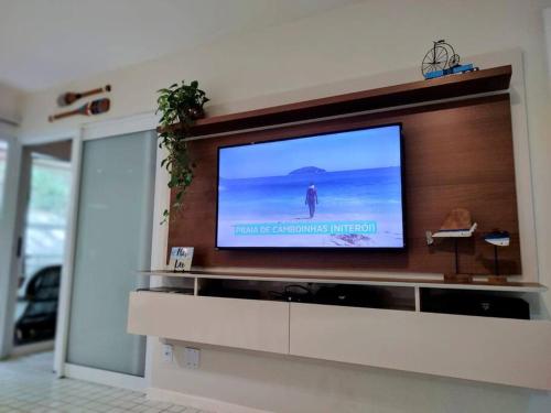 a flat screen tv on a wall in a living room at Apto Pé na Areia Condomínio Oceanside Camboinhas in Niterói
