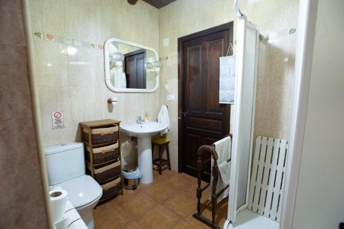 a bathroom with a sink and a toilet and a mirror at Casa Tiquio Montaña Palentina in Rabanal de los Caballeros