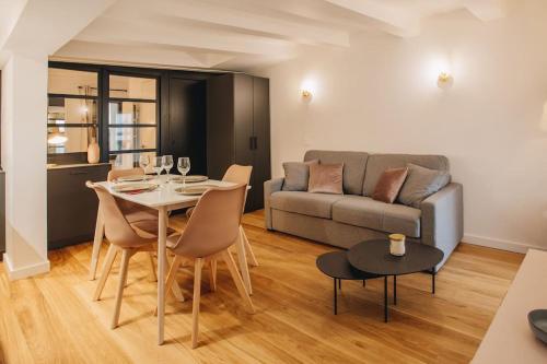 uma sala de estar com uma mesa e um sofá em La Vie en Rose - Luxe, calme & hypercentre - 3* em Annecy