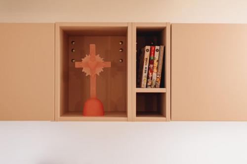 ein Bücherregal mit Kreuz und Spielzeug in der Unterkunft La Vie en Rose - Luxe, calme & hypercentre - 3* in Annecy