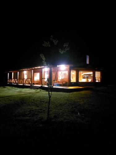a cabin at night with lights in the dark at Origenes Ecolodge de Montaña in El Bolsón