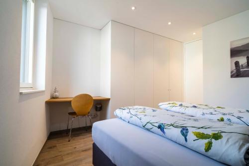 a bedroom with two beds and a desk in it at Zweite Heimat in Lochau