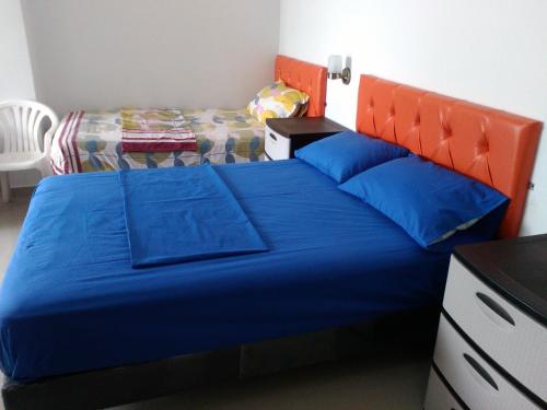 a bedroom with a blue bed with an orange headboard at Hotel Almond Beach in Tonsupa
