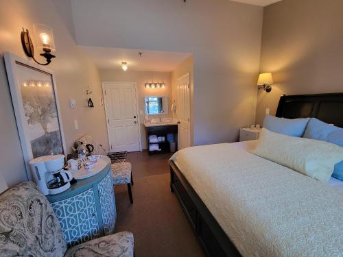 a bedroom with a large bed and a table and a chair at The Georgetown Inn in Canmore