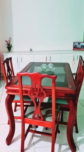 a red wooden table with two chairs around it at Casa com banheira prox USP e Centro in Ribeirão Preto