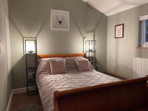 a bedroom with a bed with two lamps on it at Tulip Cottage in Wisborough Green