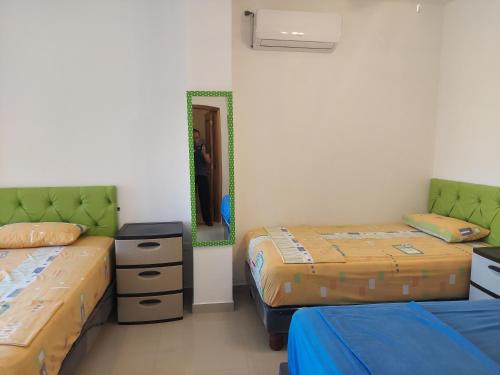 a room with two beds and a mirror at Hotel Almond Beach in Tonsupa