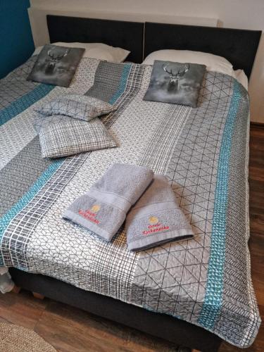 a bed with three pairs of towels on it at Ostoja Karkonoska in Podgórzyn