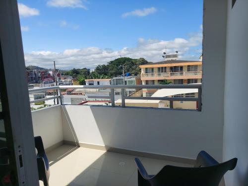 a balcony with chairs and a view of a building at Hotel Almond Beach in Tonsupa