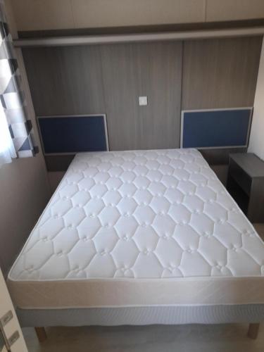 łóżko w pokoju z białym materacem w obiekcie le mobile home Le Victory situé au Camping Le Rio w mieście Noyelles-sur-Mer