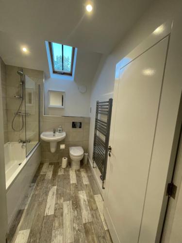 a bathroom with a toilet and a sink and a shower at Ebor Mill's Cottage in Haworth