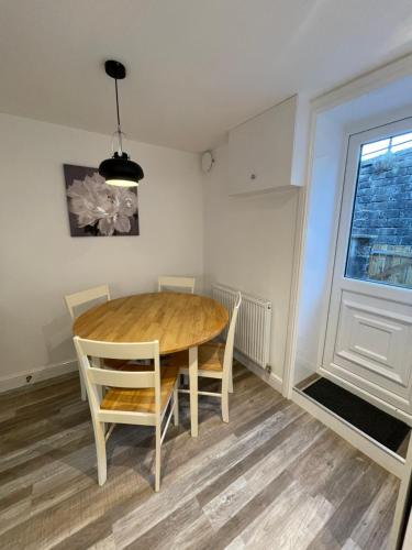 uma sala de jantar com uma mesa de madeira e cadeiras em Ebor Mill's Cottage em Haworth