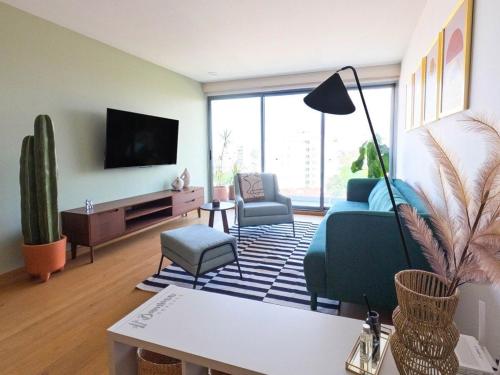 a living room with a couch and a tv at Amazing City Views Condesa Roma By Bamboo Skylife in Mexico City