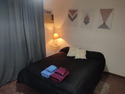 Un dormitorio con una cama con dos toallas encima. en Departamento 224, en San Juan