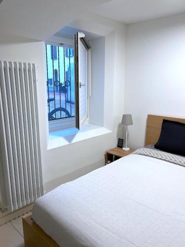 a bedroom with a white bed and a window at The Hidden Studio; Comfy & close to the Lake in Lugano