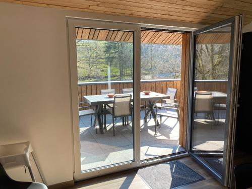 a screened in porch with a table and chairs at Le chalet du kanal in Winseler