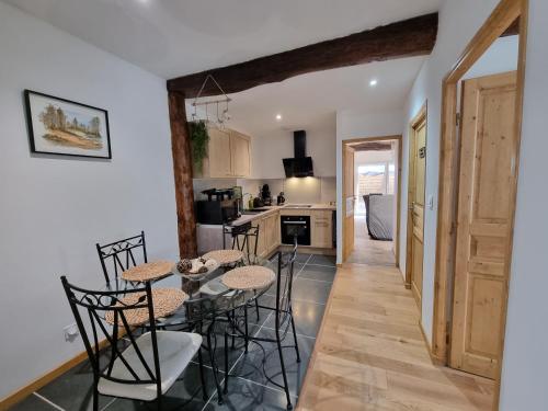 une cuisine et une salle à manger avec une table et des chaises dans l'établissement LE GITE SPA DU CEDRE BLEU, à La Tourette-Cabardès