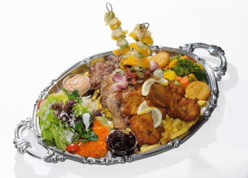 a platter of food with meat and vegetables at Werfenerhof in Werfen