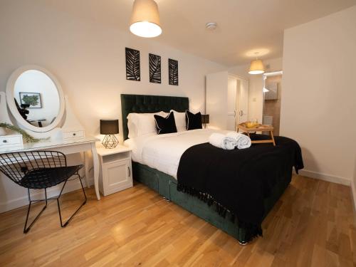 Schlafzimmer mit einem Bett, einem Schreibtisch und einem Spiegel in der Unterkunft Modern & Central - KING Bed, Super FAST Wi-Fi in Cambridge