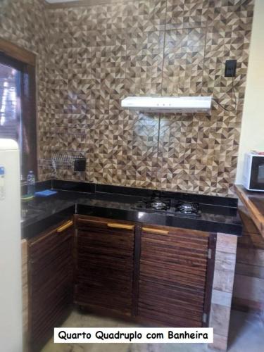 a kitchen with a counter top and a wall at Sanctuary Pirenópolis Suítes e Flats in Pirenópolis