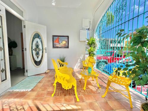 a room with yellow chairs and a table and a window at Oasis Inn in San Juan