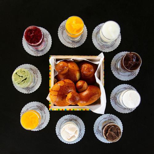 Una mesa con una caja de pasteles y tazas de bebidas. en Zahara, en Catania