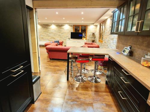 eine Küche mit einer Bar und ein Wohnzimmer mit einem Sofa in der Unterkunft Place Royale pour 10 à 12 personnes à 30 mèt des pistes de Ski et Vtt in Métabief