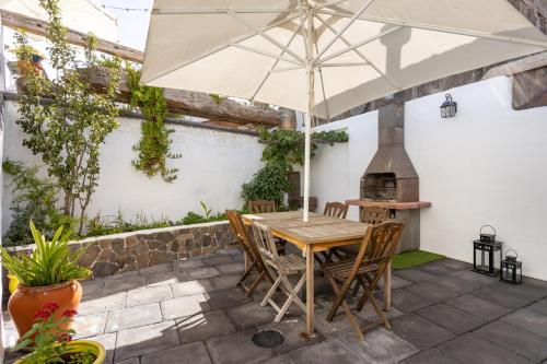 a table and chairs with an umbrella on a patio at Casa SotoMayor in Santiago del Teide