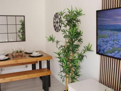 a dining room with a table and a plant at Modern 2 Bed house - HS2, NEC & Birmingham Airport in Marston Green