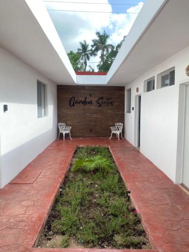 a courtyard with two chairs and a sign on a building at Garden Suites Comalcalco in Comalcalco
